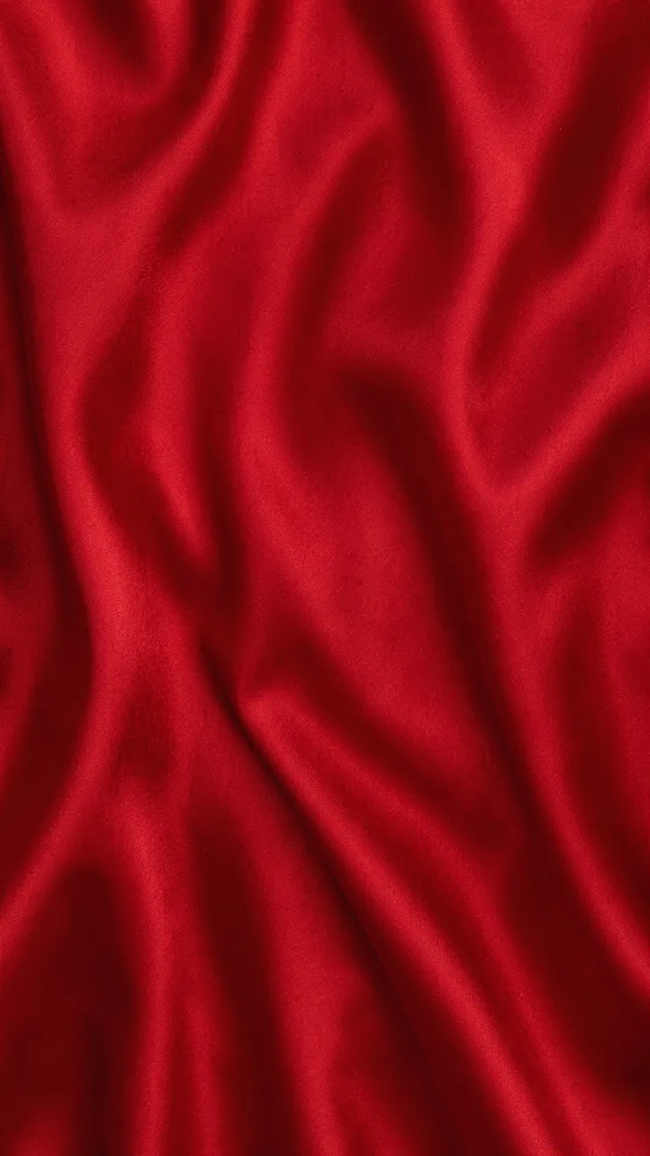 Vertical close-up of rippled deep crimson satin fabric with soft folded light gradients