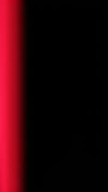 A smooth vertical crimson gradient light leak runs along the left edge of a pure black background