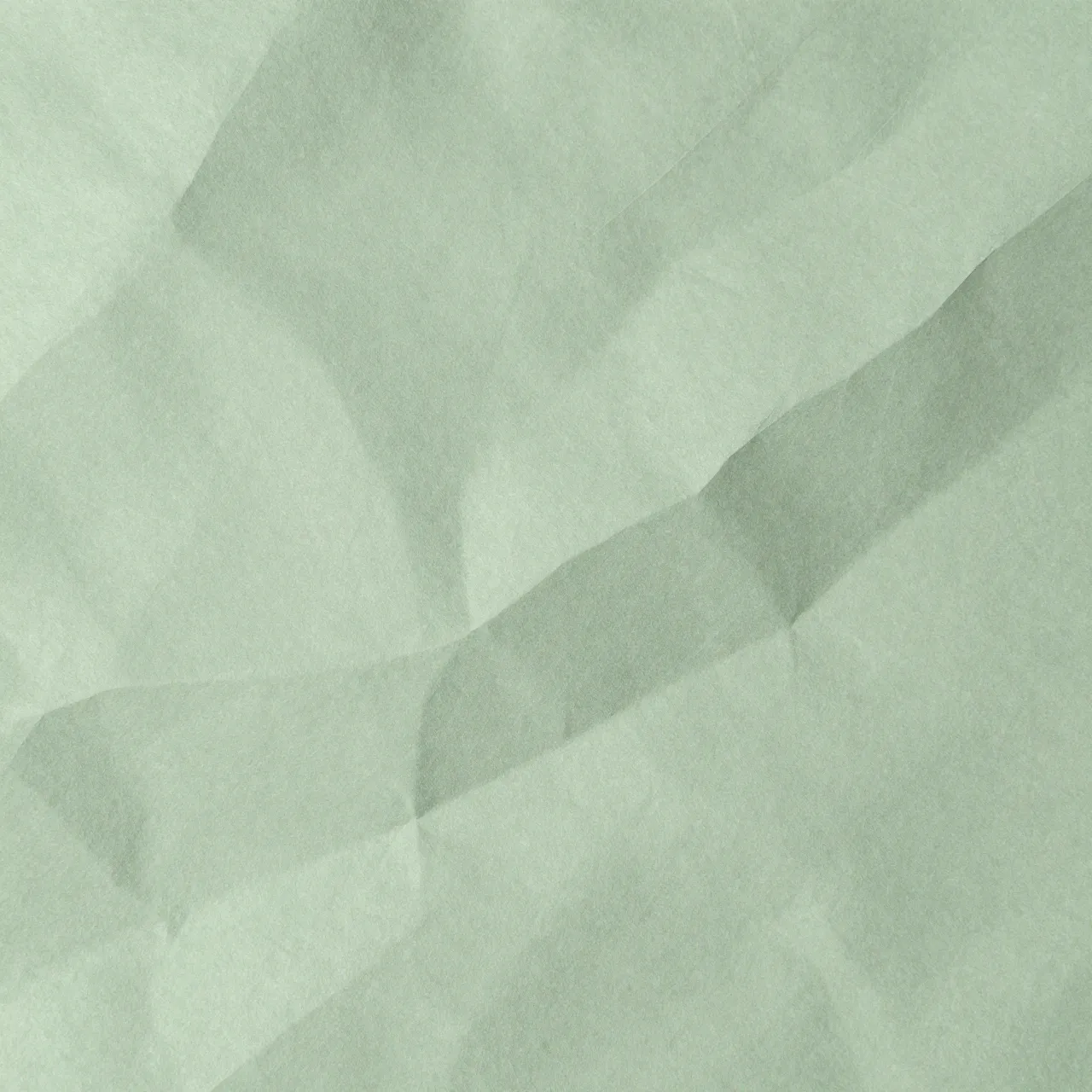 Full frame close up of smoothed crinkled sage green paper with soft highlights along its creases