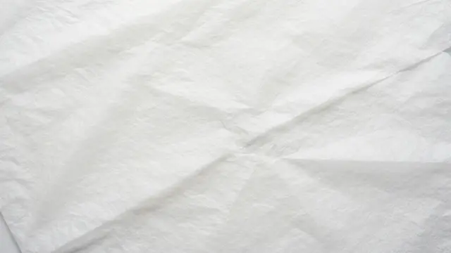 Full frame close-up of soft overlapping crumpled white tissue paper with subtle pale shadows
