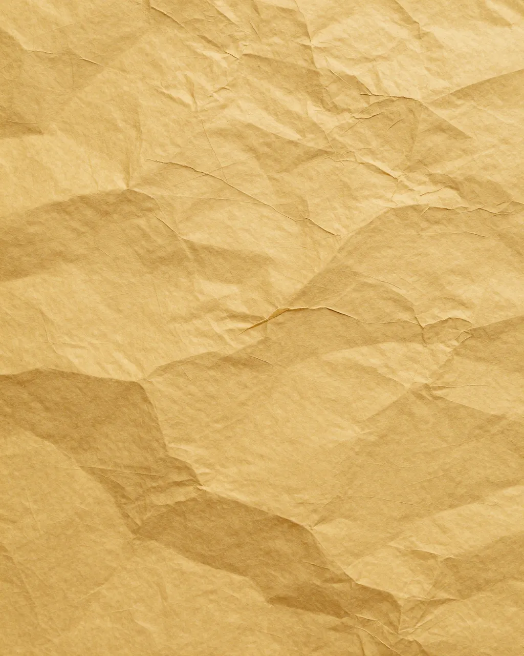 Full frame close-up of smoothed crumpled mustard yellow paper with a web of sharp creases under even lighting