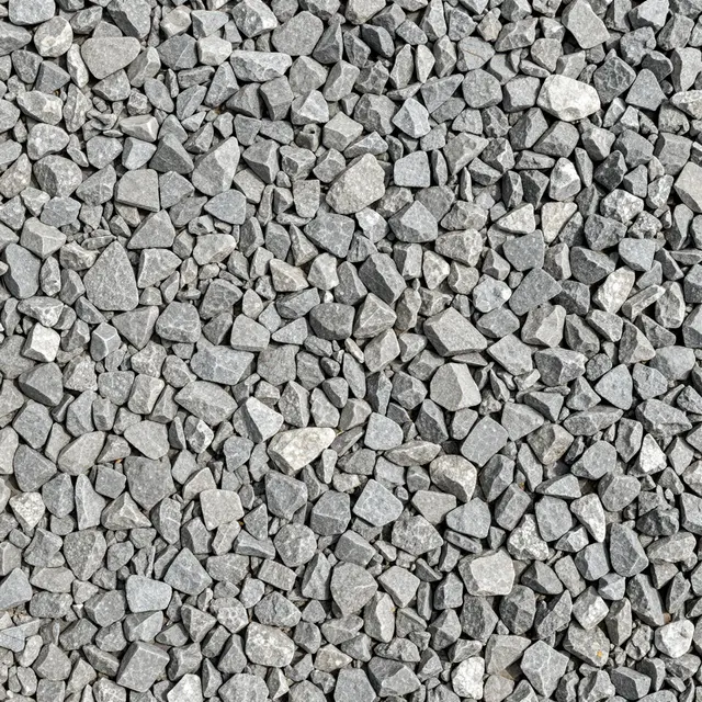 Top view of a full frame flat surface covered in sharp angular gray crushed gravel chips of mixed sizes