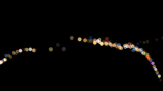 A gentle curving line of colorful soft bokeh circles rests against a pure solid black background