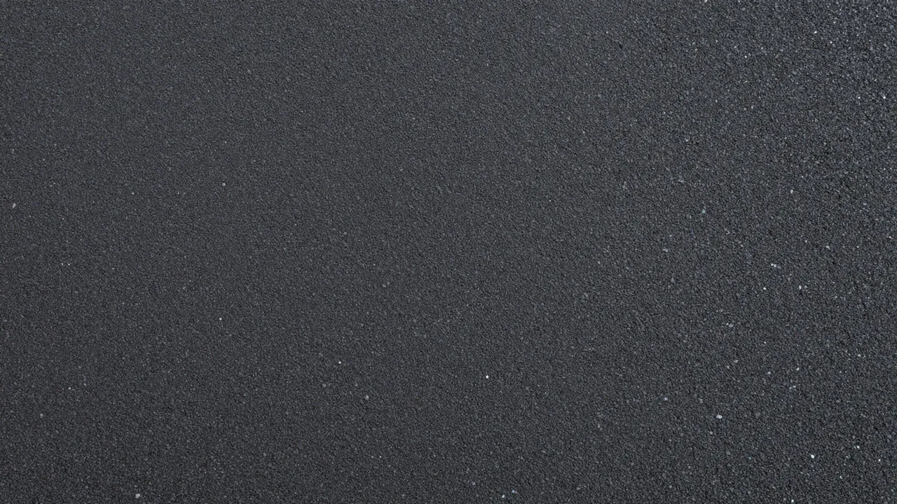 Top view of smooth dark asphalt with tiny embedded light aggregate stones under even flat lighting