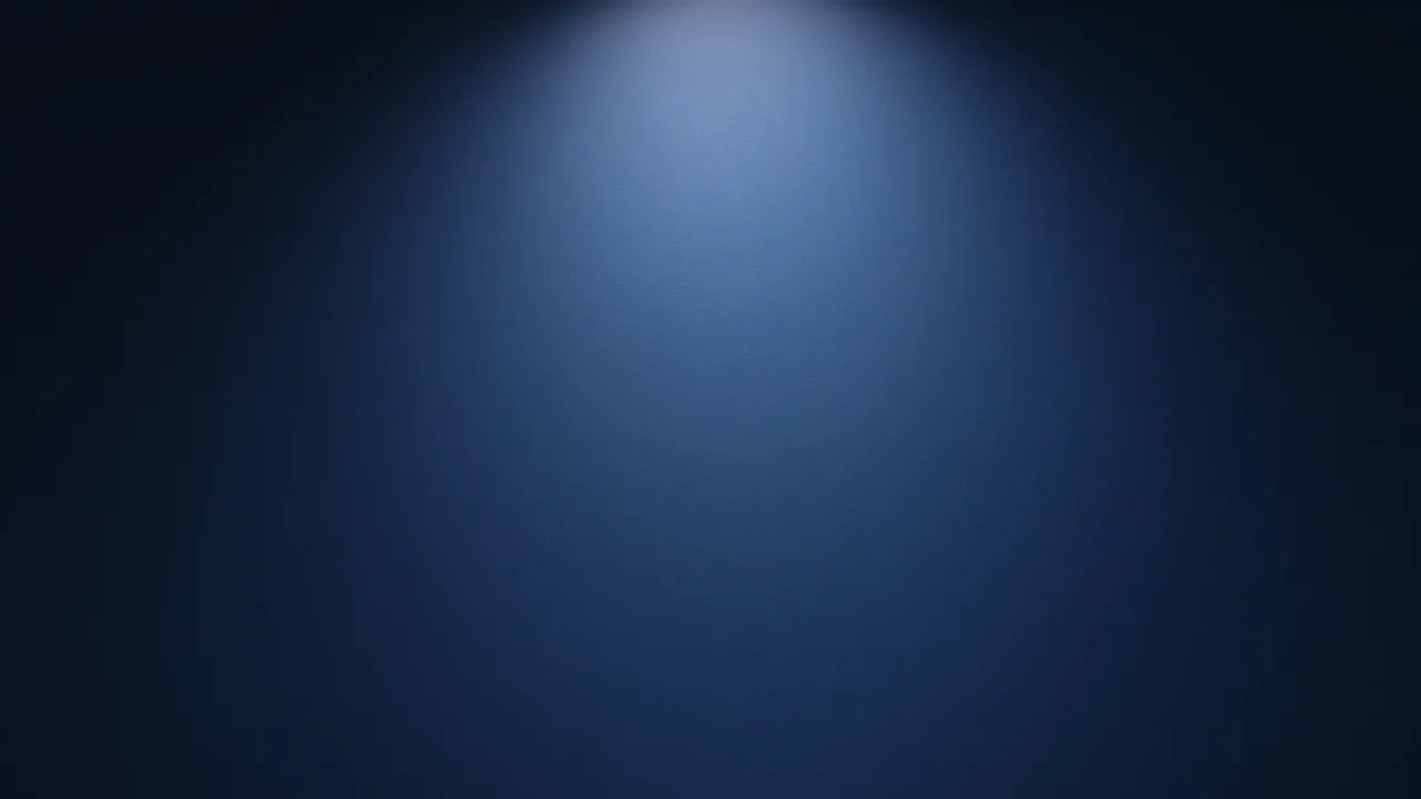 A smooth dark blue paper studio backdrop with a soft spotlight glow at the center fading to black edges