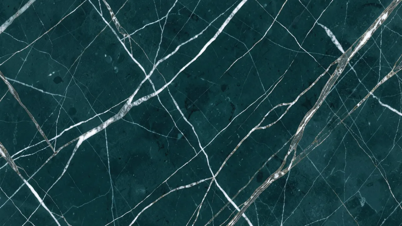 Full frame close up of deep teal marble with delicate white and metallic silver veins