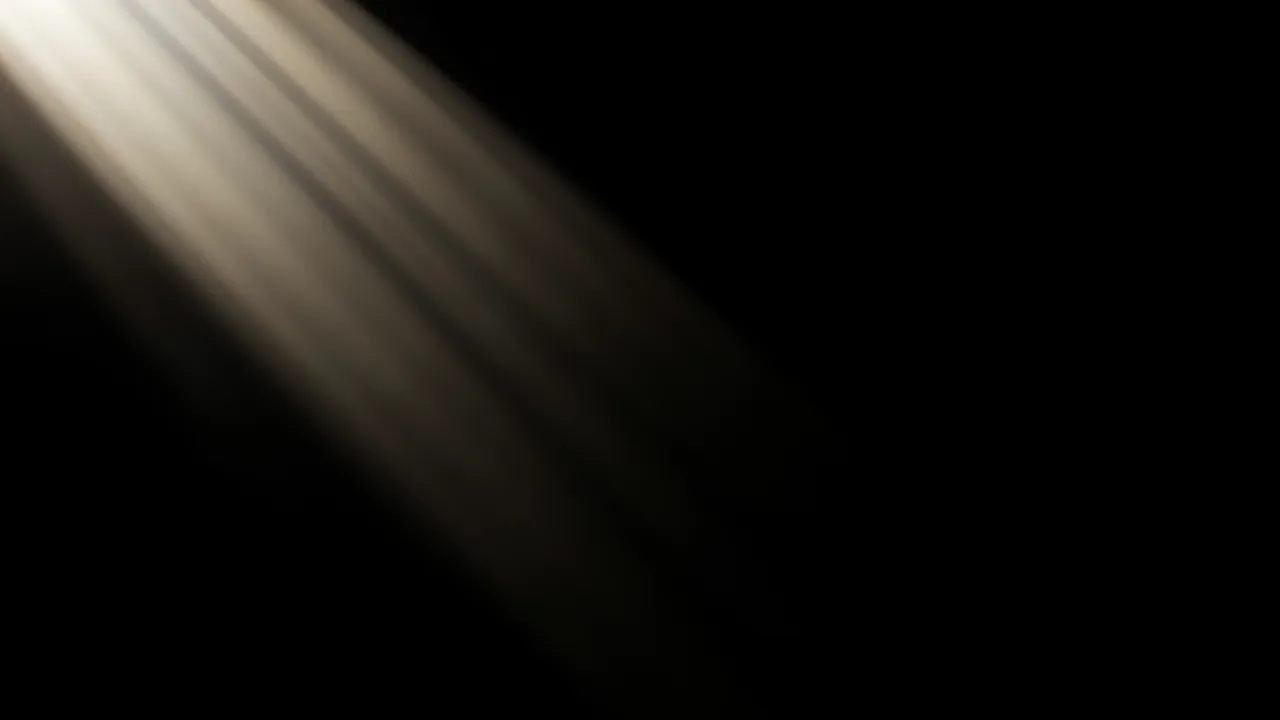 Soft warm diagonal god rays stream from the top left across a pure black background