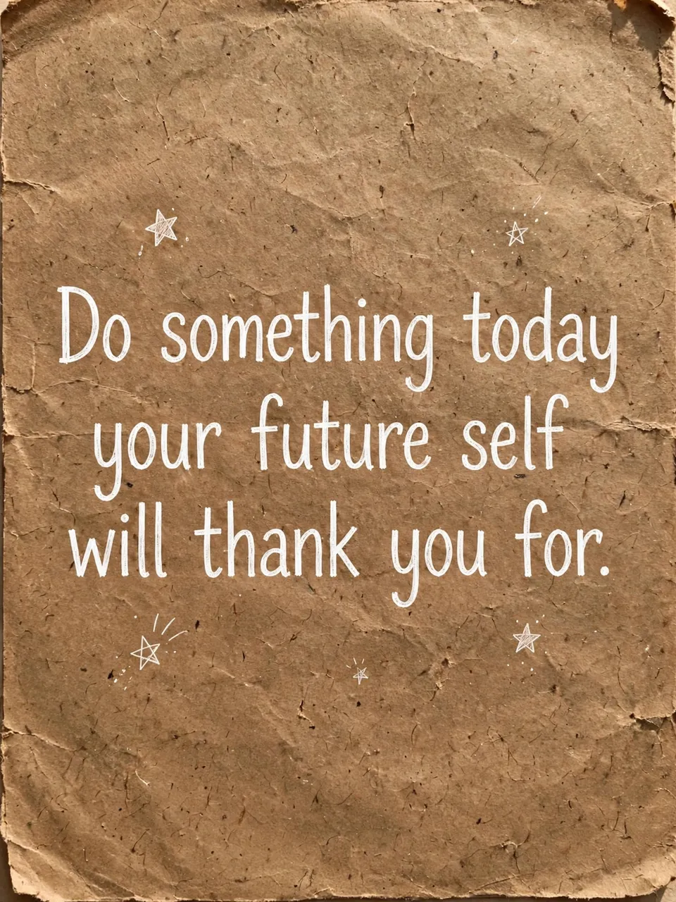 White hand-drawn quote and small doodled stars on textured crumpled brown kraft paper reading "Do something today your