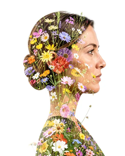 Double exposure portrait of a woman in profile filled with mixed blooming wildflowers against a plain white background