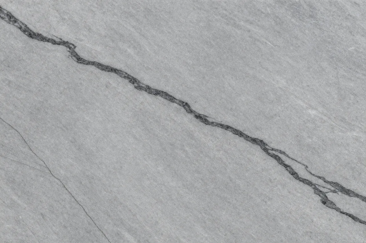 Full frame close up of a dove gray marble surface with flowing dark charcoal veining