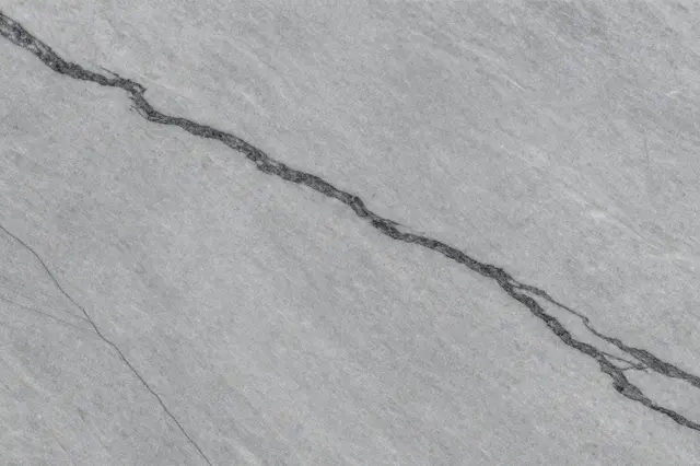 Full frame close up of a dove gray marble surface with flowing dark charcoal veining