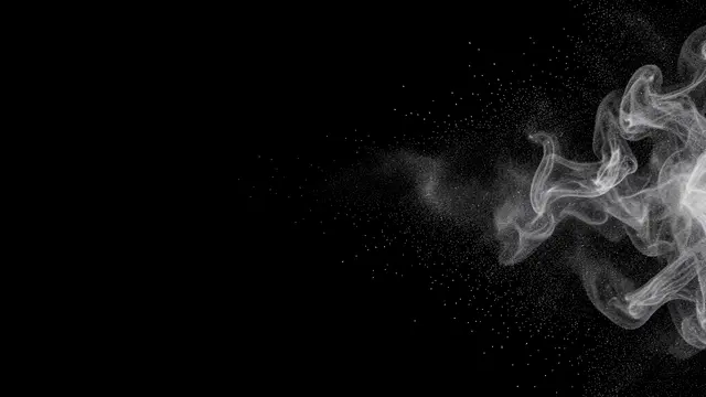 Wispy white smoke dissolving into fine drifting particles against a solid pure black background