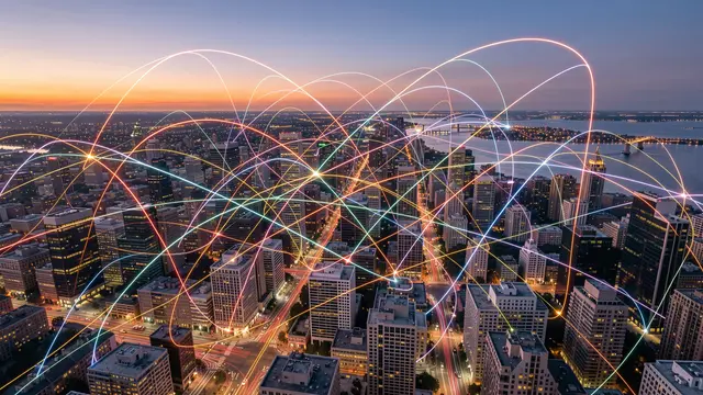 Aerial view of a downtown city at dusk overlaid with glowing multicolored digital connection lines