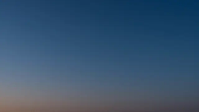 Smooth gradient of deep navy evening sky fading to a soft pale horizon band after dusk