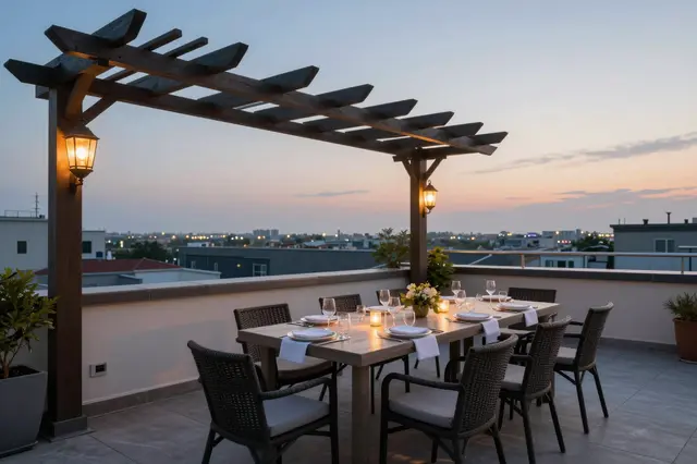 Set dining table under a wooden pergola on a rooftop terrace at sunset overlooking a city