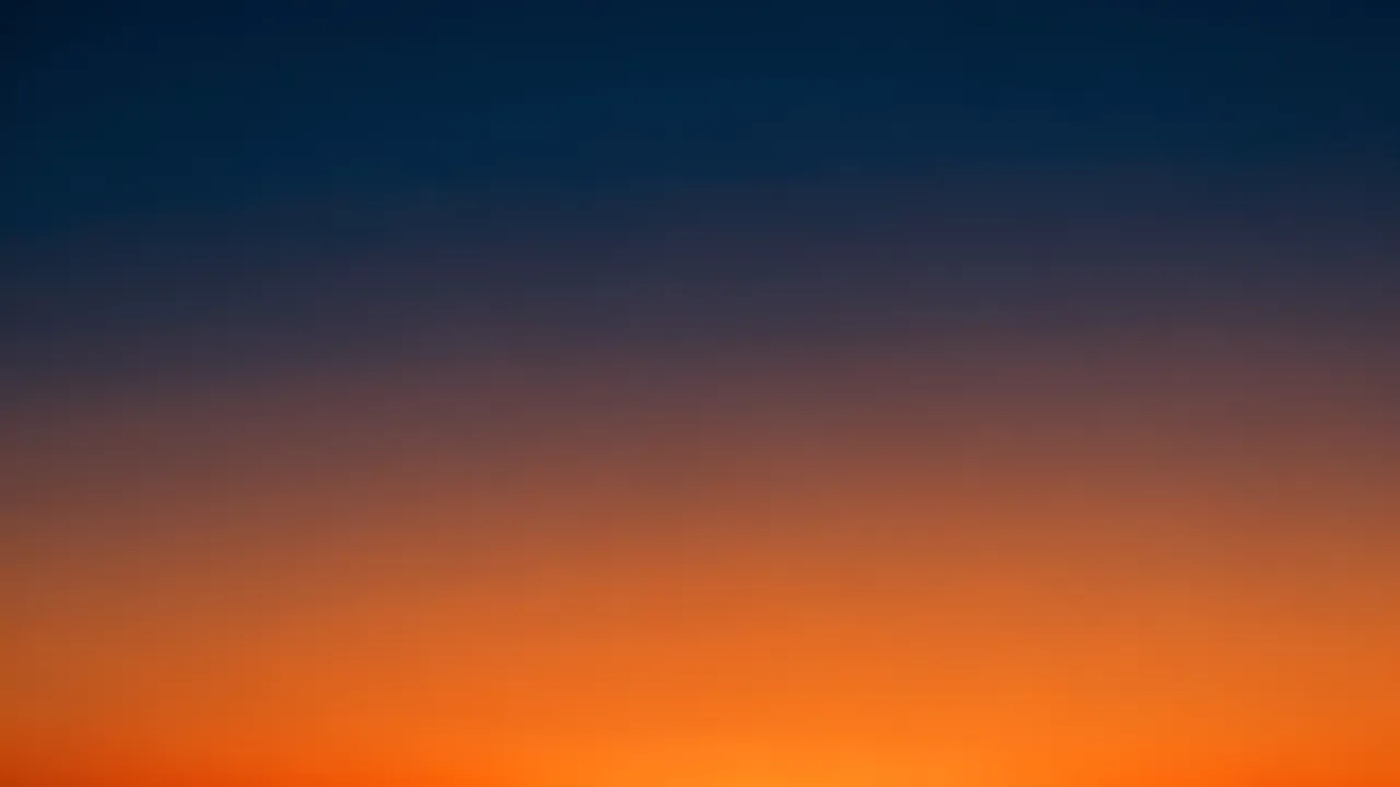 A smooth seamless gradient shifting from deep midnight blue to warm orange like a dusk sky