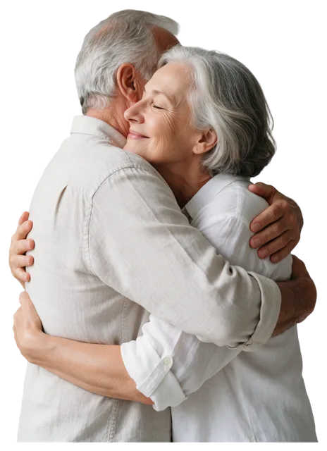 Side view of an elderly couple hugging closely, the woman resting her face on the man's shoulder with a soft smile