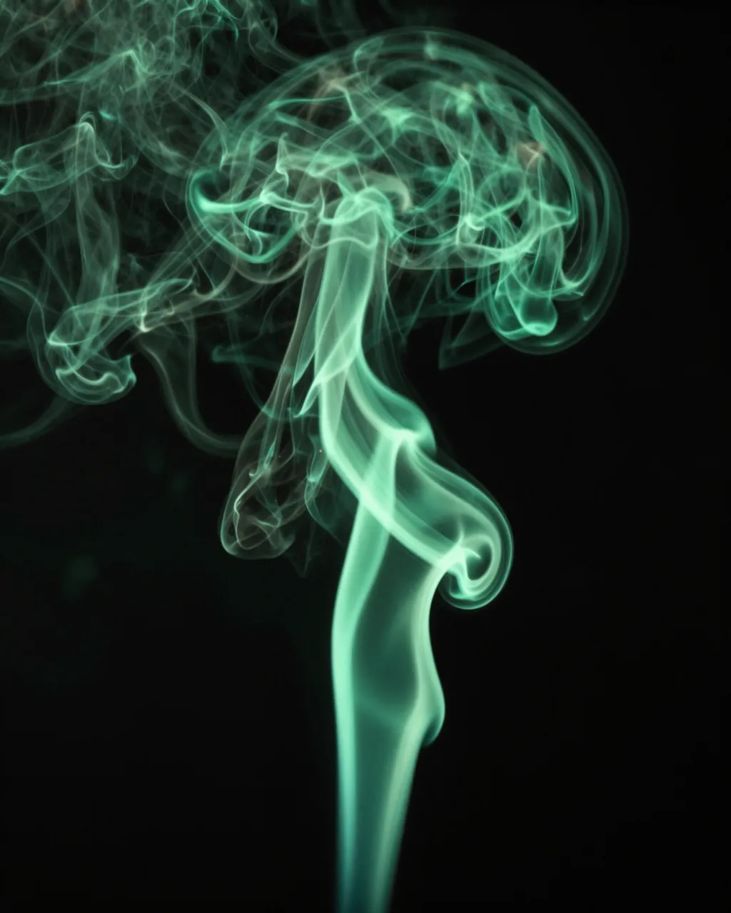 Bright emerald green curling smoke swirls upward against a solid black background