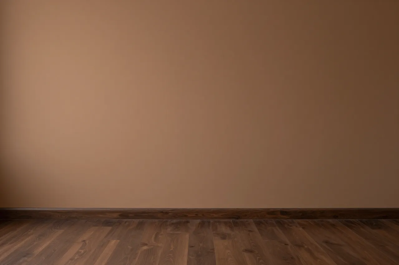 Empty interior with warm brown wall, dark wooden floor and soft even lighting