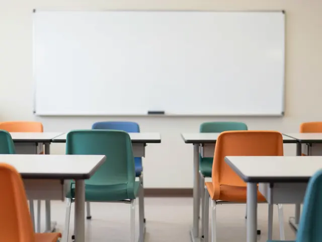 Empty modern classroom with colorful chairs, desks and a blank wall-mounted whiteboard