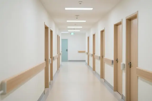 Quiet empty modern hospital corridor illuminated by soft recessed ceiling lighting