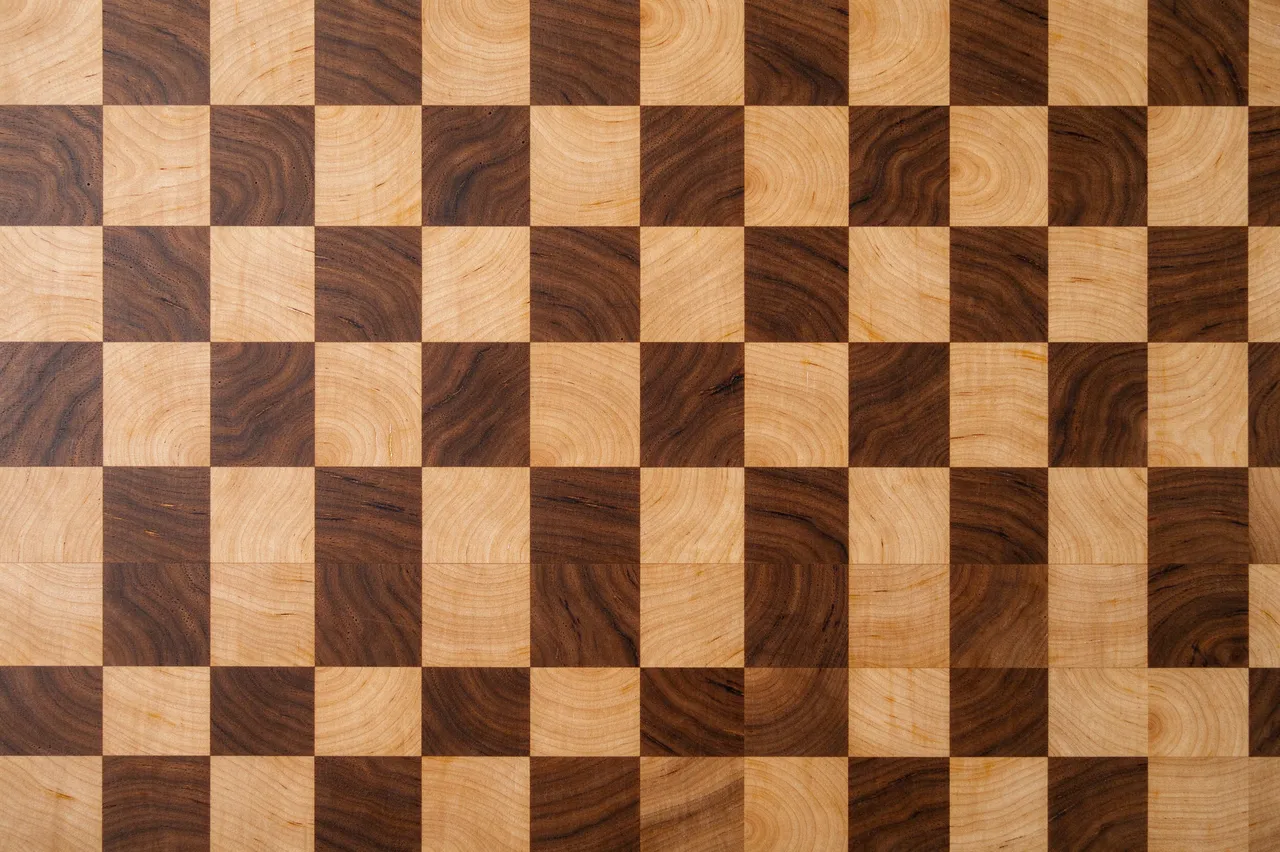 Top view of a full frame checkerboard end grain butcher block with alternating pale maple and dark walnut wood squares