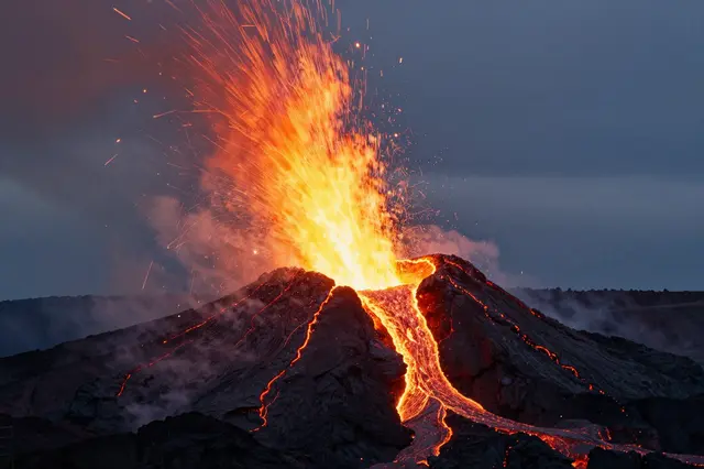 An active volcano erupts at night, spraying glowing lava and fiery sparks above its crater.