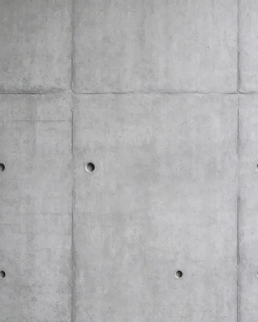 Full frame close-up of smooth cast concrete wall panels with form seams and bolt holes under flat even light