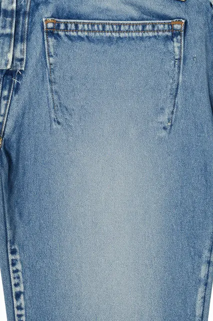 Close-up of light-wash faded denim fabric showing stitched pocket and soft whiskering details