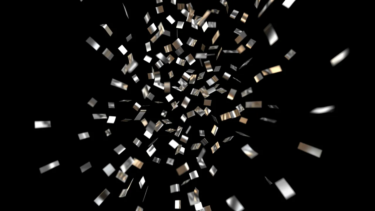 Shiny silver and gold metallic confetti falls with motion blur against a solid pure black background