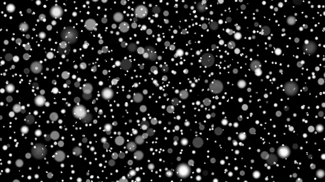 Scattered soft white and gray bokeh snow particles float against a solid pure black background