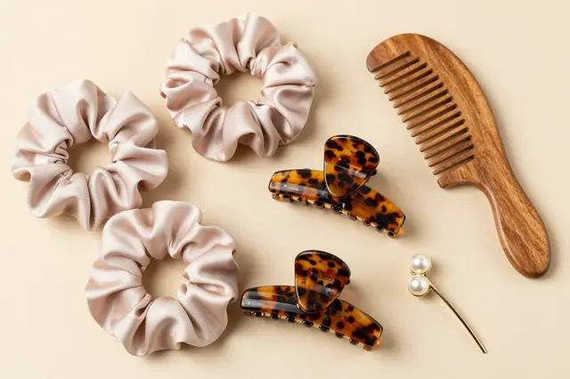 Neutral toned hair accessories arranged in a flat lay on a soft beige background