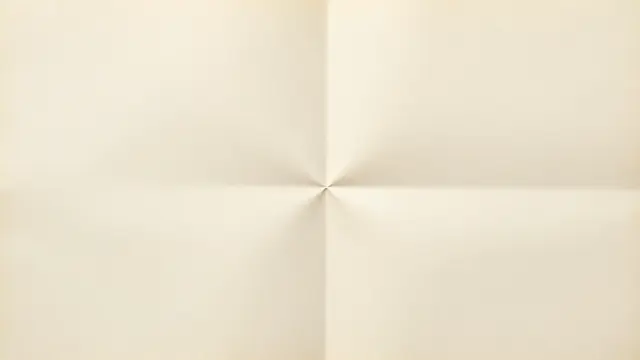 Blank cream aged paper with cross fold creases and soft raking light falling across its surface