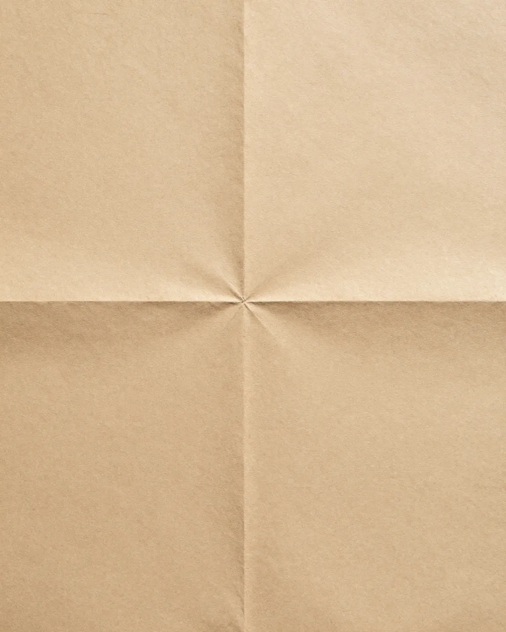 Full frame close-up of old tan folded paper with intersecting creases filling the entire frame