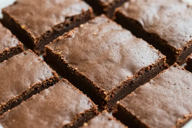 Close-up view of a batch of cut square fudgy chocolate brownies arranged on a flat surface