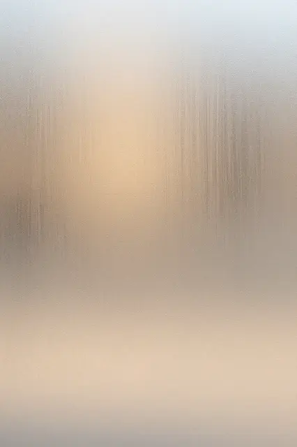 Textured frosted glass with soft blurred warm peach light glowing through its surface