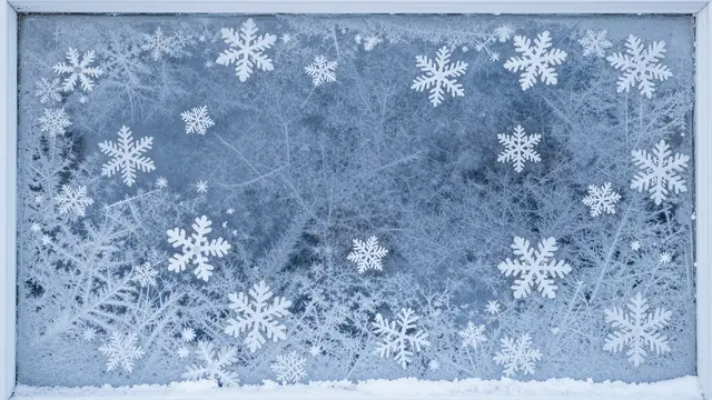 Frosted blue window glass decorated with snowflakes, with central copy space for holiday designs