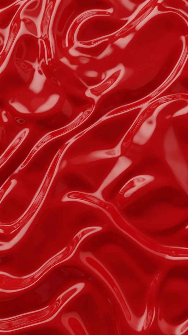 Vertical full frame view of smooth glossy cherry red liquid with flowing curved ripples and soft reflective highlights