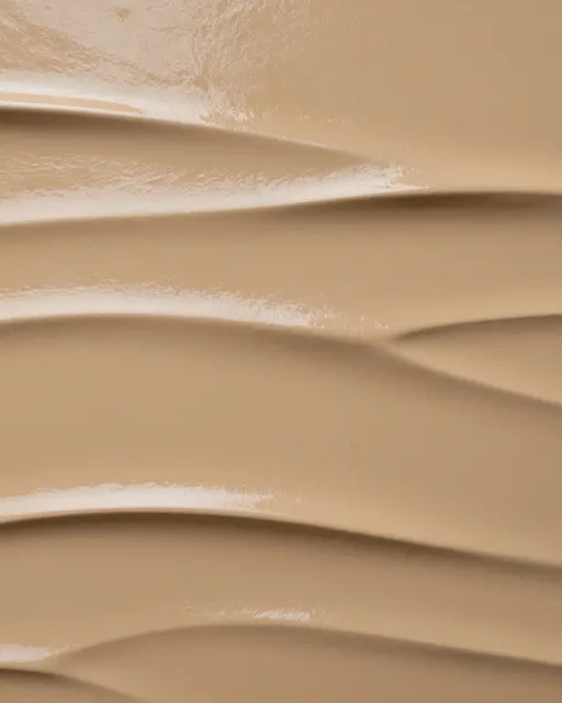 Full frame close up of glossy burnished ochre tadelakt plaster with soft wavy ridges under flat light