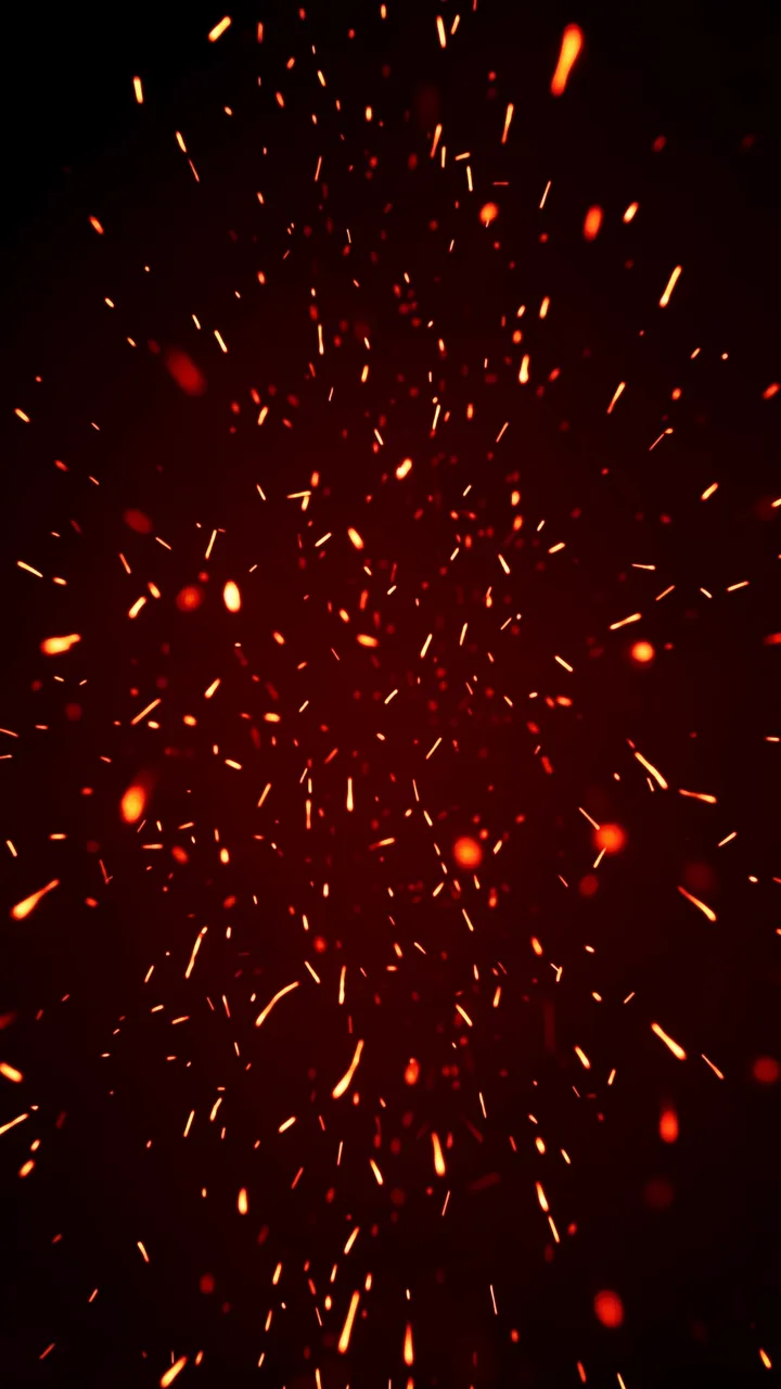 Bright orange and red glowing embers drift upward across a dark black background