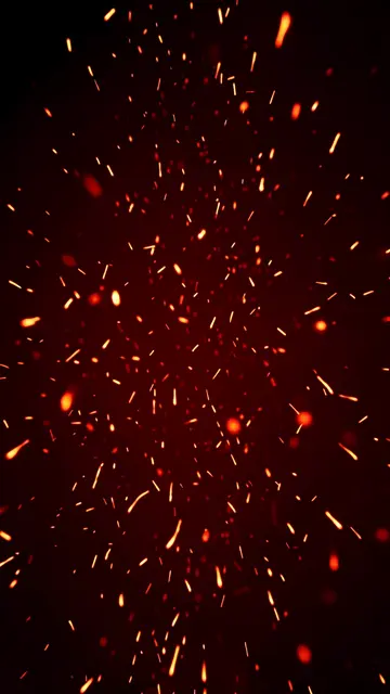Bright orange and red glowing embers drift upward across a dark black background