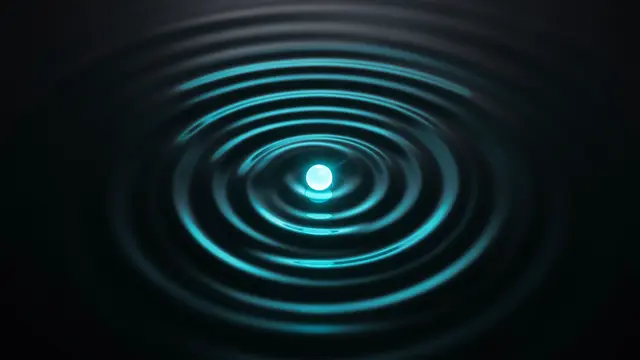 A small bright glowing orb sits at the center of spreading concentric cyan light ripples on a dark surface