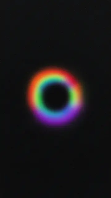 A soft blurry rainbow gradient ring glows against a grainy dark black background