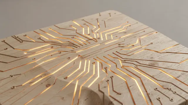 Pale wood slab with carved circuit traces lit by warm glowing light from the grooved lines