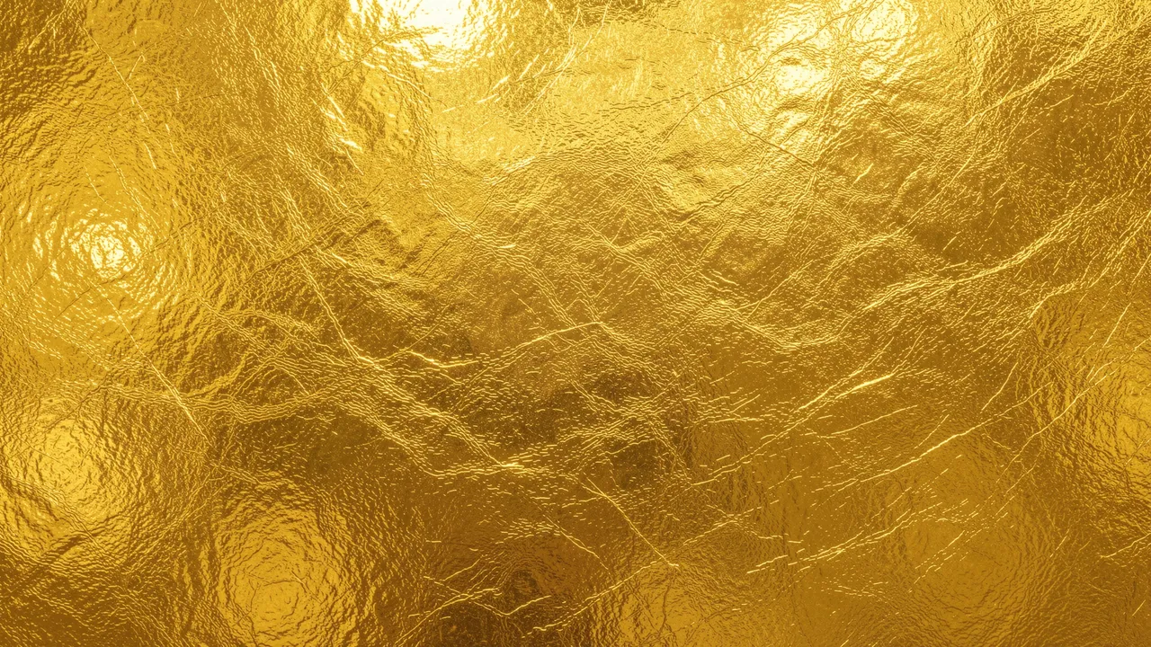 Crinkled metallic gold foil texture with soft bright light reflections across its surface