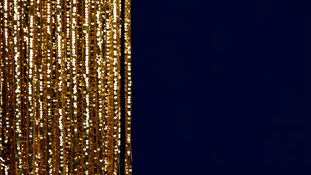 Shimmering gold sequin curtain on the left next to empty solid deep navy copy space on the right