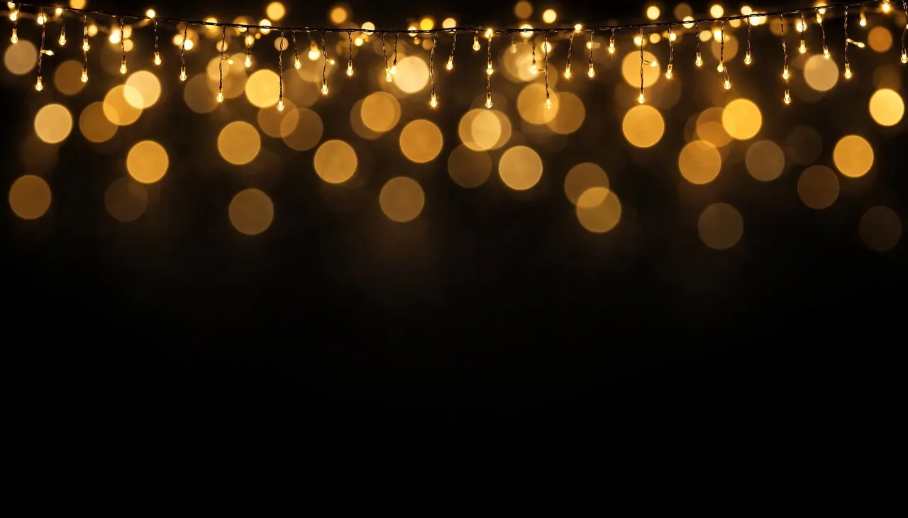 Hanging warm golden fairy lights create soft bokeh against a deep black background