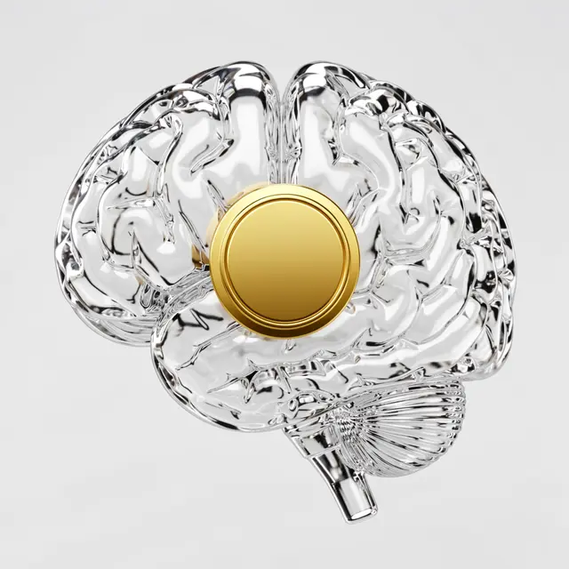 Transparent glass brain model with a blank golden circular chip set at its center against a light gray background