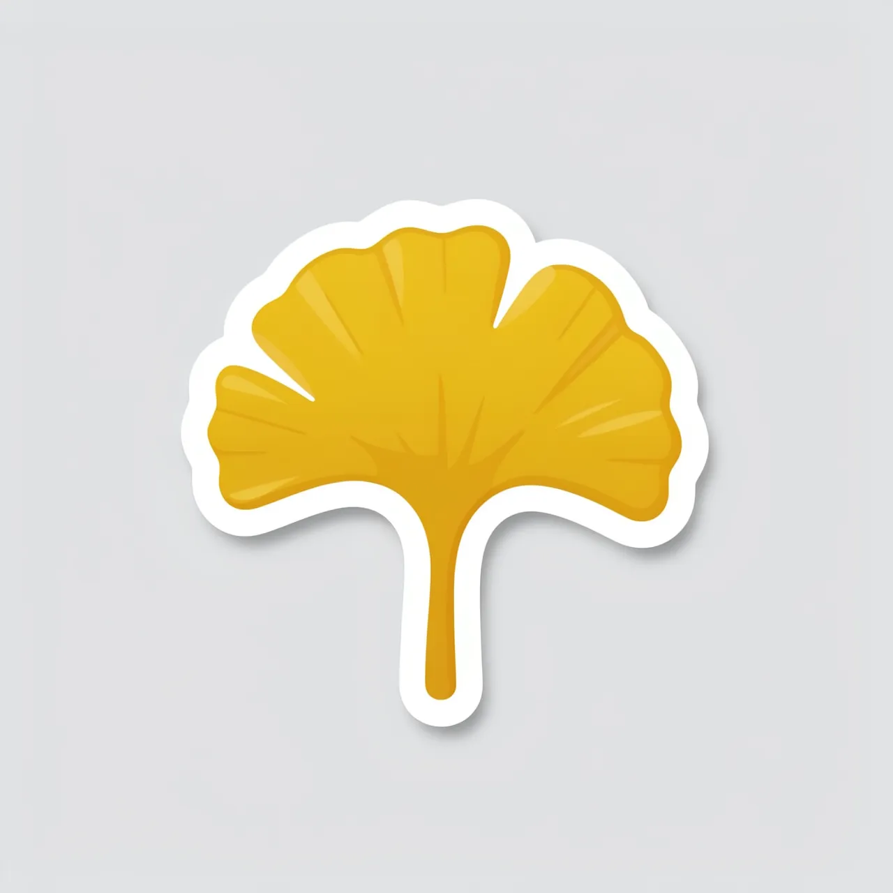 A die-cut sticker of a golden ginkgo leaf with a white border rests on a plain light gray background