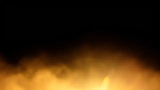 Warm hazy golden lens flare washes across the lower portion of a pure black background